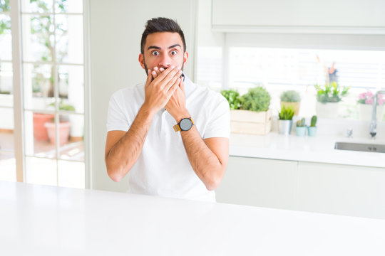 Handsome hispanic man casual white t-shirt at home shocked covering mouth with hands for mistake. Secret concept.