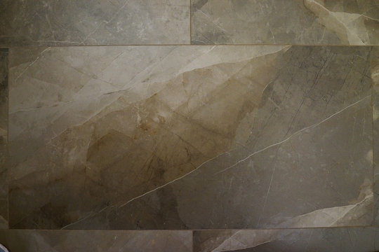 The texture of natural stone (granite, marble) on the floor of a large stoneware tile