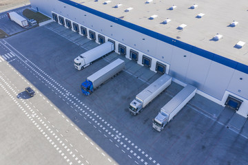 Delivering or Supply concept image. Trucks loading at facility. Logistics Center. Aerial View