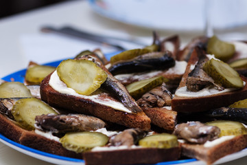 Sandwiches with sprats. Bread, mayonnaise, fish, pickles.