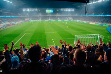 Big fans support at football stadium. Photo, professional soccer game, fans