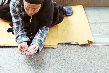 Close-up hand of homeless man and wish money from people on walking street.