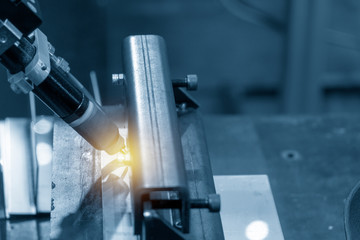 The robotic welding  the square tube in the light blue scene with the lighting effect.The hi-technology manufacturing process in industrial 4.0 concept.