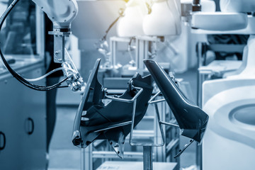 The robotic arm spray the painting in automotive parts manufacturing process.The industrial 4.0 manufacturing concept.