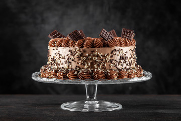 Decorated chocolate cake on dark background
