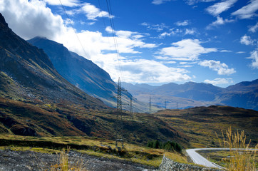 Electricity Pylon over the Mountain with Blue Sky and Clouds in Switzerland.
