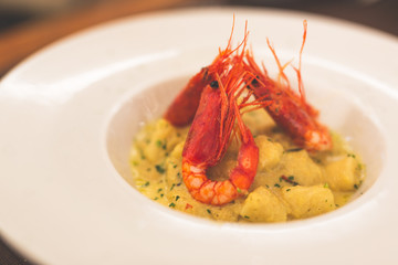 Gnocchi with red shrimps on a white plate
