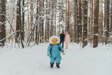 Fototapeta na wymiar Walking family with a child. Family walks in nature in winter. Winter family walk in nature. A lot of snow.