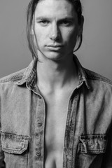Portrait of a handsome long-haired man with freckles dressed in a denim shirt