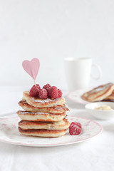 Bright mood breakfast table with a stack of pancakes and coffee cups and heart decor