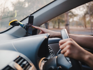 driver's hand use the phone on phone holder while driving in the car