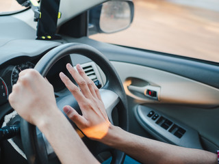 Closeup Driver's hand pressing on a car horn while driving