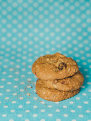 Oatmeal and raisin cookies on pastel blue polka dot background.