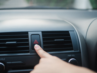 Driver's finger pressing car's emergency button in the car