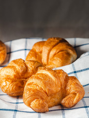 fresh croissants on checkered towel.