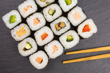 variations of maki sushi rolls with chopsticks