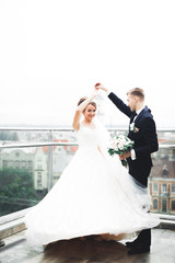 Naklejka premium Beautiful bride spinning with perfect dress on the balcony