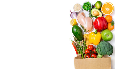 Healthy eating background. Healthy food in paper bag meat, fruits, vegetables and pasta on white background. Shopping food in supermarket, dieting concept. Long format with copy space