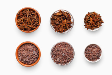 Different sized bowls with anise and black Indian salt on white