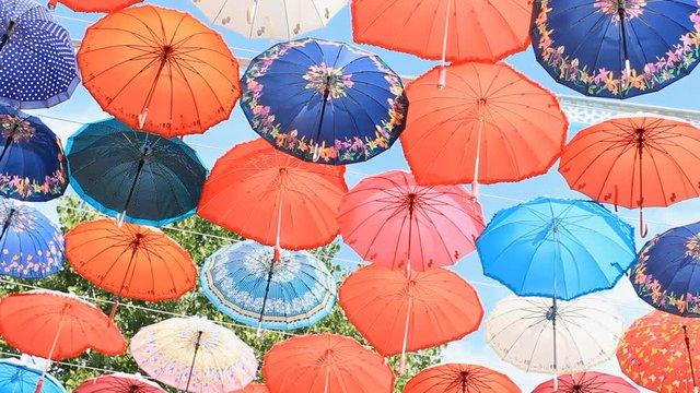 Street decorated with colored umbrellas on the blue sky