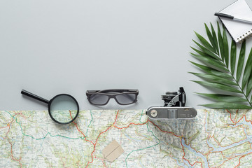 eyeglasses road map sunglasses palm leaf photo camera  top view with copy space for your text. flat lay. 
