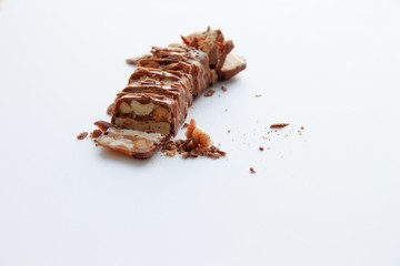 chocolate bar with nuts cut into pieces visible nuts white background