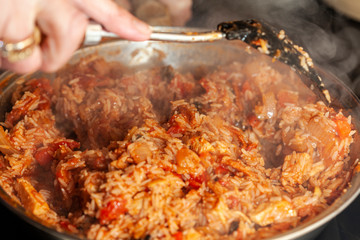 Chicken and Chorizo Jambalaya being stirred in a pan