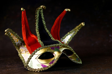 Carnival venetian Joker mask on dark background. Carnival mask side view.