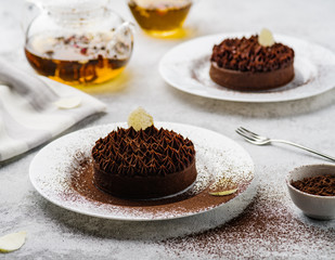 Chocolate tart with white filling. Delicate Chocolate Dessert with Flower Tea.