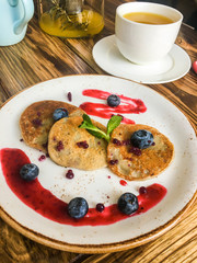 Pancakes with nuts and berries on a wooden table