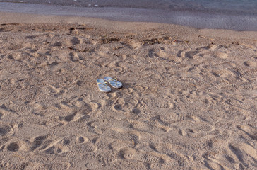 flip flops in the sand without owner