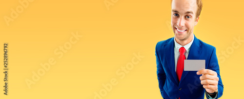 Businessman showing business or plastic card, with copyspace