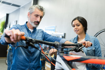 female apprentice repairing a bike in workshop