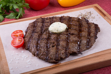Prepared steak served with butter on board