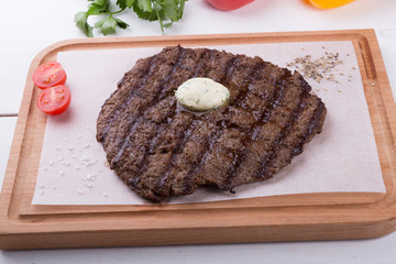 Prepared steak served with butter on board