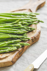 Fresh asparagus on a wooden cutting board. Preparation vegetarian healthy food.