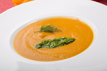 Orange soup puree served with pesto sauce