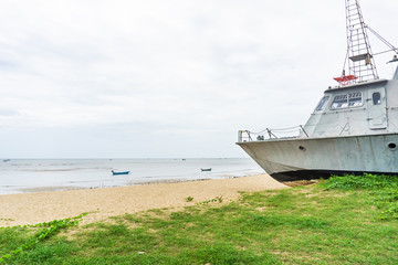 Battle metal ship on sand beach