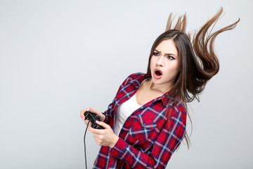 Beautiful girl with joystick on grey background