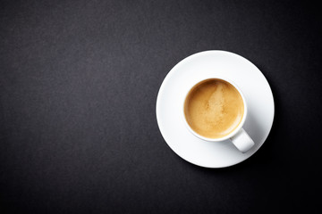 Cup of coffee on black background. Top view. Copy space.