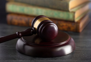 Obraz premium Judges Gavel on a Desk with Books in the Background