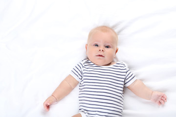 Baby lying on white bed