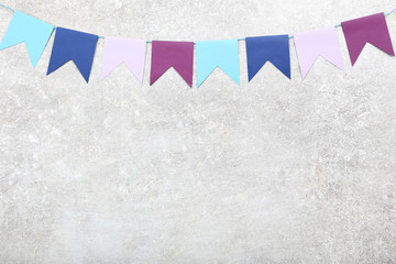 Colorful paper flags hanging on grey background