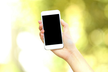 Woman holding and using smartphone on blurred background