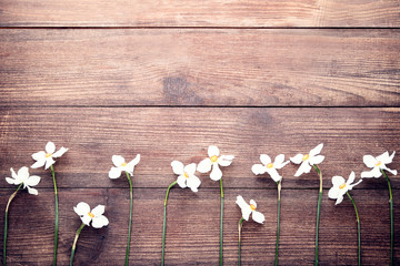 White narcissus flowers on brown wooden table