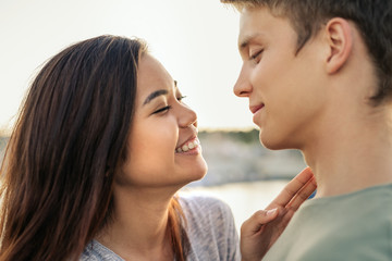 Young couple laughing while wrapped in a blanket together outside