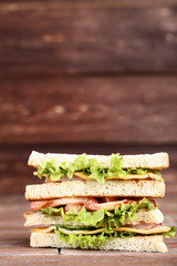 Tasty sandwich on brown wooden background