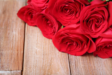 Bouquet of red roses on brown wooden table