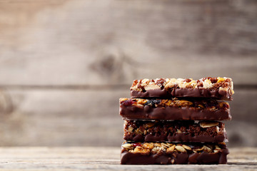 Tasty chocolate granola bars on wooden table