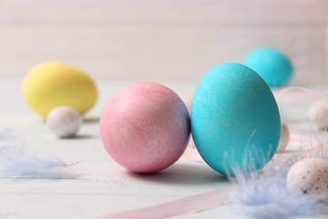  Easter composition of painted eggs and feathers on wooden background. Background for Easter, a place to insert text